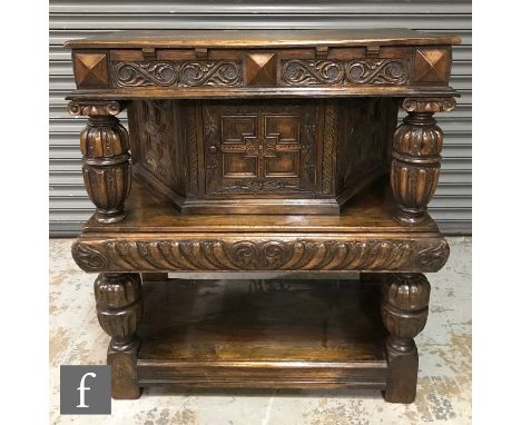 A 20th Century oak court cupboard with heavily turned pillar supports and acanthus carved detail, with a central cupboard abo