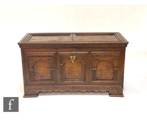 A 19th Century oak continental coffer with recessed paneled top over a geometric moulded and floral carved detailed front, on