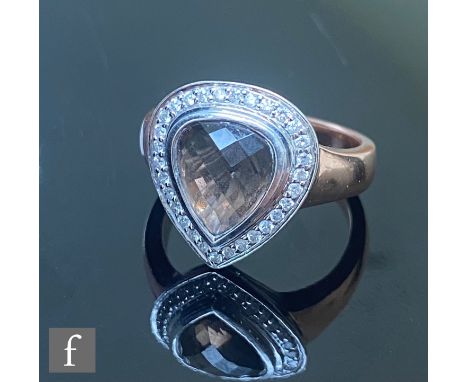 A modern 9ct rose gold smokey quartz and diamond ring, central facet cut, collar set quartz within a diamond set border, leng