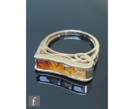 A 9ct ring set with four graduated citrenes from yellow to red in colour, channel set to a rectangular head, weight 3.6g, rin