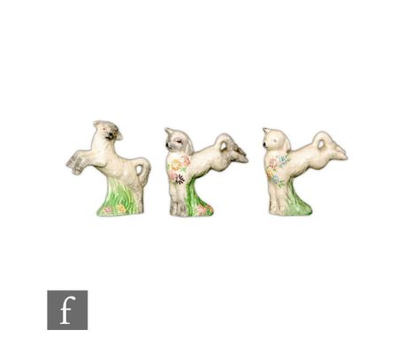 A set of three Clarice Cliff Spring Lamb figures with flowers and grasses picked out in enamels, Newport Pottery and Wilkinso