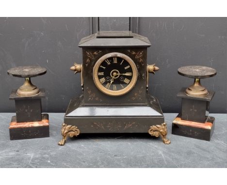 A late Victorian slate and brass mantel clock,&nbsp;28.5cm high; together with a similar pair of side urns. (3) 