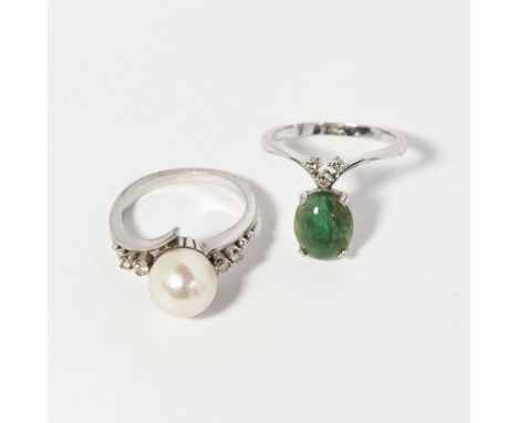 An emerald and diamond set wishbone ringclaw set with an oval emerald cabochon below a trio of small round brilliant cut diam