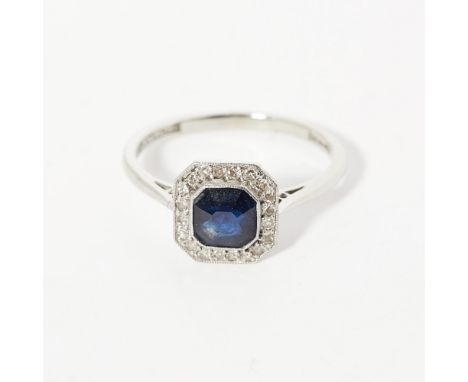 A sapphire and diamond set cluster ringmillegrain set with a trap cut sapphire, in a border of eight cut diamonds, to a plain