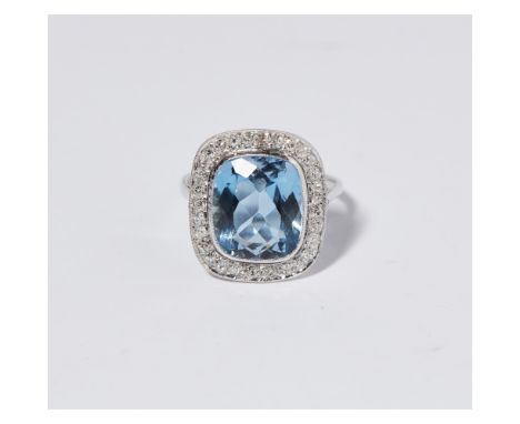 An aquamarine and diamond set cluster ringmillegrain set with an oval cushion cut aquamarine, in a border of eight cut and ro