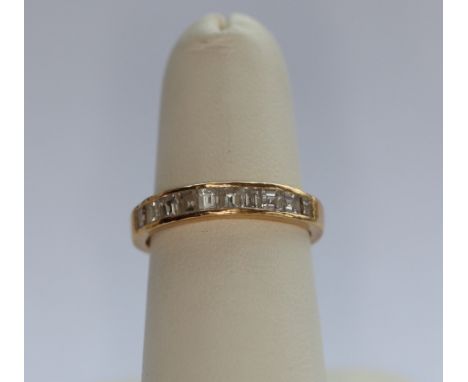 A diamond set half-eternity ringchannel set to the front with ten graduated rectangular cut diamonds, stamped 750Ring size: L