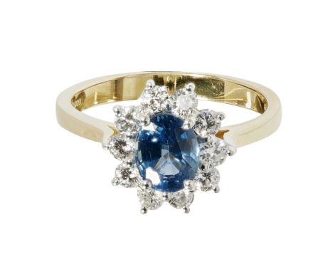 A sapphire and diamond set cluster ringclaw set with an oval cut sapphire, in a border of round brilliant cut diamonds, to a 