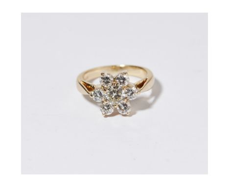 A diamond set cluster ringclaw set with a round brilliant cut diamond, in a border of six smaller round brilliant cut diamond