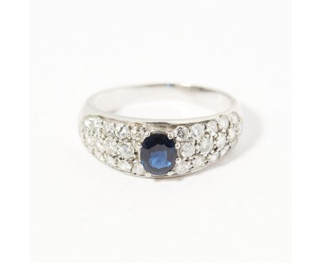 A sapphire and diamond set ringclaw set with an oval sapphire in a surround pavé set with graduated round brilliant cut diamo