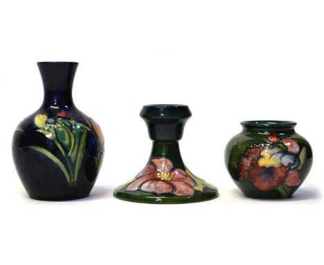 Three items of Moorcroft to include a Hibiscus candlestick on green ground (second) 10cm diameter, an Orchid pattern bulbous 