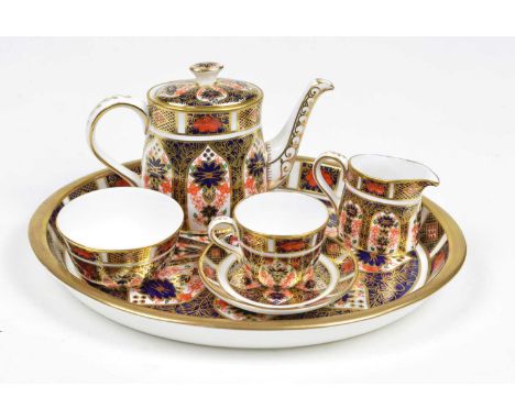 Royal Crown Derby Imari 1128 pattern miniature tea set on an oval tray, comprising teapot, milk and sugar, one teacup and sau