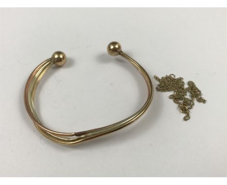 A yellow-metal tri-coloured torque bangle, tests as gold, together with a fine neck chain, stamped 9K (a/f), 5.5g
