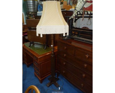 An Oak Standard Lamp by Woods Furniture Co. having a turned column and an elegant beige and cream lattice patterned shade wit