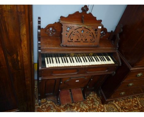 A Satinwood cased organ/harmonium having a 4 1/2 octave keyboard and a nicely fretworked music stand with a label "Bart and C