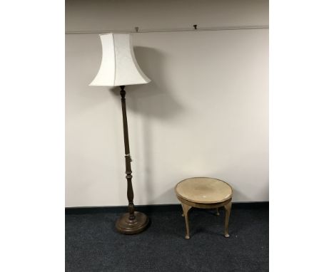 A circular walnut glass topped table together with a standard lamp and shade