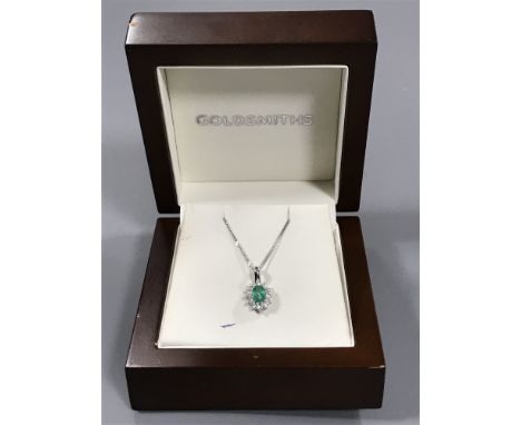 An 18ct white gold emerald and diamond cluster pendant on chain