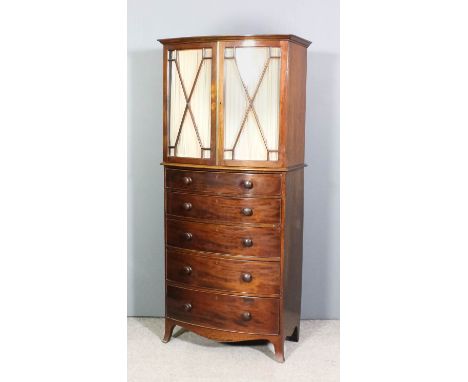 A mahogany bow-front millinery cabinet of Georgian design with moulded cornice, fitted two shelves enclosed by a pair of astr