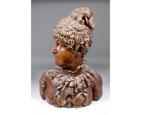 A 19th Century Continental carved pear wood life sized portrait bust of a young woman with elaborately dressed hair with comb