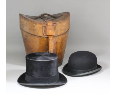 An early 20th Century leather hat box with top hat by the Army & Navy, and a bowler hat by Morgan & Ball