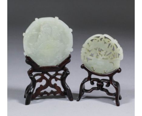 A Chinese celadon jade circular pendant pierced and carved with a peony in a bowl, 2.375ins (61mm) diameter, and another carv