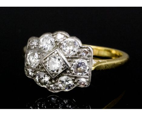An Edwardian 18ct gold mounted diamond ring, the face set with central old cut diamond approximately .20ct surrounded by six 