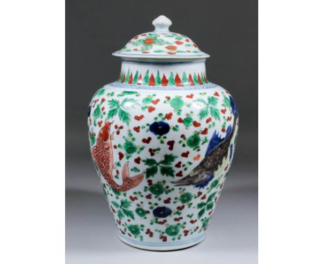 A Chinese Wucai enamel porcelain baluster shaped vase and cover, enamelled in colours with four differing fish and stylised l