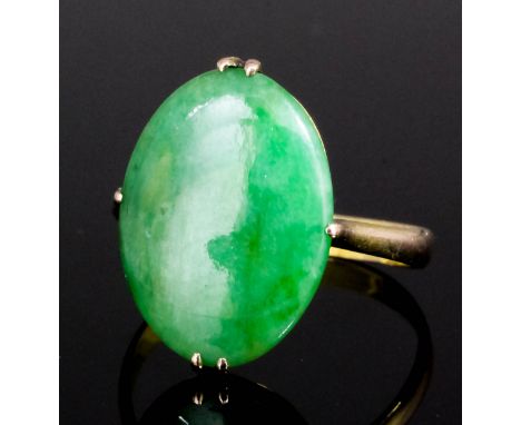 A Chinese 9k gold mounted jadeite ring, the oval cut panel 18mm x 12mm overall (modern - gross weight 2.1 grammes - ring size