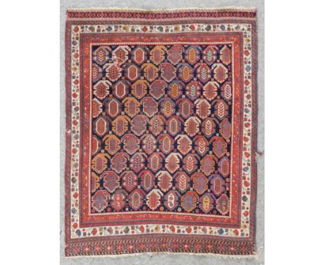 An antique Caucasian rug woven in colours with a numerous rows of boteh on a navy blue ground within five stripe borders and 