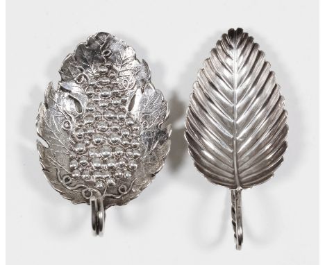 A George III silver leaf pattern caddy spoon, the die stamped bowl with a bunch of grapes and vine leaves and twisted wirewor
