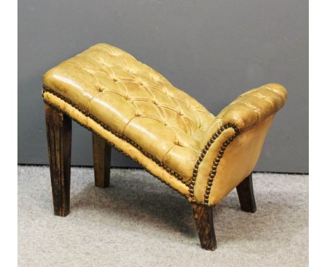 A gout stool of Georgian design upholstered in tan leather and buttoned, on stained wood and fluted front legs, 12ins wide x 