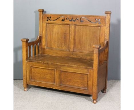 A Victorian panelled oak hall bench of Arts & Crafts design with pierced frieze, lifting wood seat, on turned bun feet, 43ins