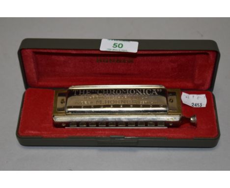 A boxed 'The Chromonica' Hohner harmonica.