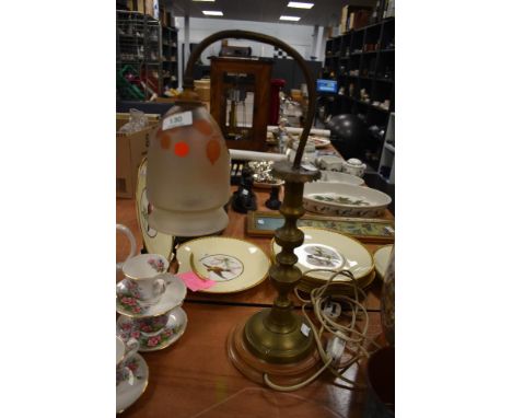 An early 20th century brass lamp on wooden base, having frosted glass shade with leaf decoration.
