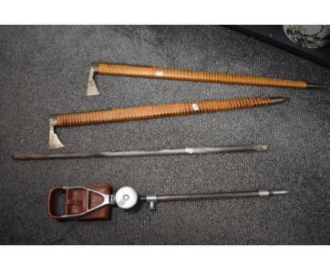 A vintage shooting stick and two ceremonial axes or similar having wooden handles with brass brackets to sides and engraved d