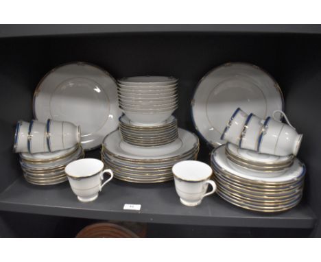 A collection of Noritake 'Impression' pattern dinner wares, having white ground with teal blue banding and gilt accents, cups