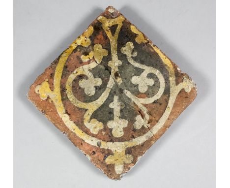 An English Medieval encaustic tile decorated with a white slip inlay of foliage design with a corresponding circular frame, p