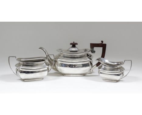 A George V silver rectangular three piece tea service of plain panelled form with angular loop handles, comprising - teapot w