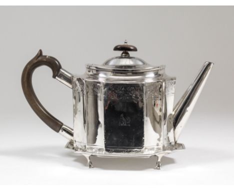 A George III silver teapot, the oval body with incurved panels and angular spout engraved with leaf bandings, the domed cover