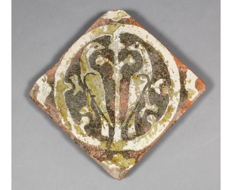 An English Medieval encaustic tile decorated with a white slip inlay of two birds flanking a tree within a circular frame, th