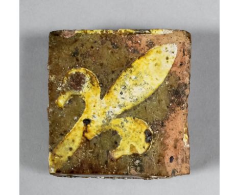 An English Medieval encaustic tile decorated with white slip inlay of a fleur-de-lis, 2.5ins, set diagonally (13th/14th Centu