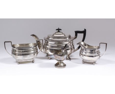 A George V silver rectangular three piece tea service of Georgian design with reeded mounts and moulded bodies, on four ball 