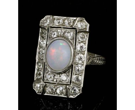 A 1920s platinum mounted opal and diamond ring, the rectangular face set with a central cabochon cut white opal approximately