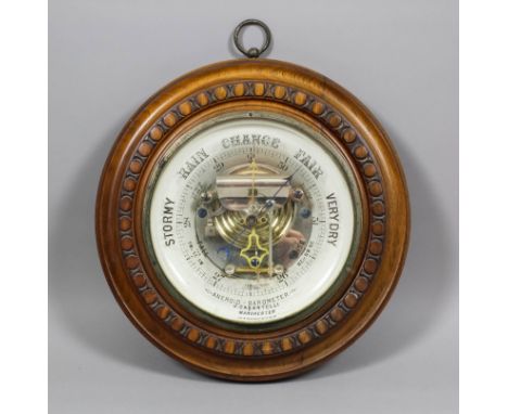 A late Victorian aneroid barometer by J. Casartelli, Manchester, with 6.25ins diameter glass dial, in turned and carved case,