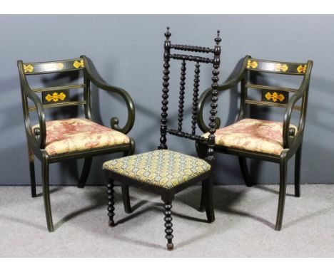 A pair of green painted open armchairs of Regency design, decorated in gilt with leaf ornament, the drop-in seats upholstered