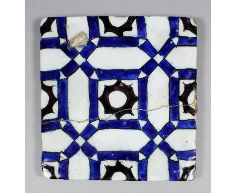 A 17th Century Damascus tile painted in underglazed blue and aubergine and outlined in black with a repeating design of geome