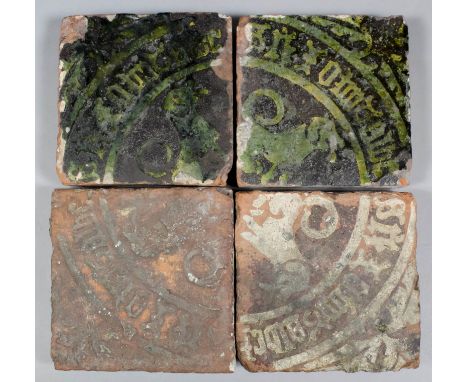 Four rare inscribed Medieval encaustic tiles each with a repeating design forming a quarter of a circle decorated in white sl