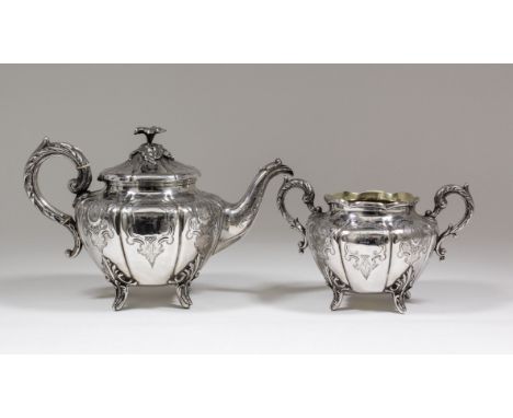 A Victorian silver circular teapot of bulbous panelled form, the whole engraved with scroll and shell ornament, with floral a