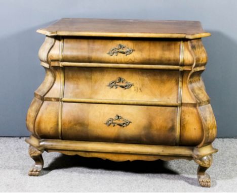A Dutch walnut bombe fronted commode of 18th Century design with quarter veneered top, fitted three long drawers with bold sh