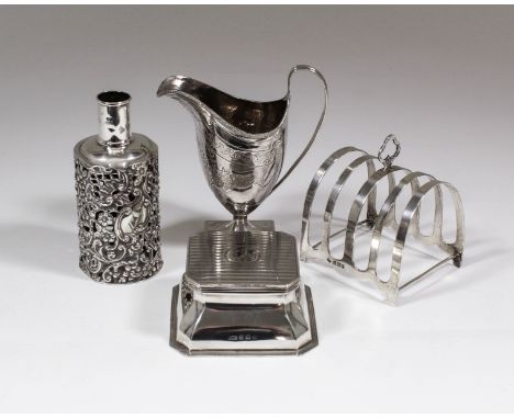 A George III silver helmet pattern cream jug with bead mounts to rim, engraved with oval wreath, leaves and bright cut decora