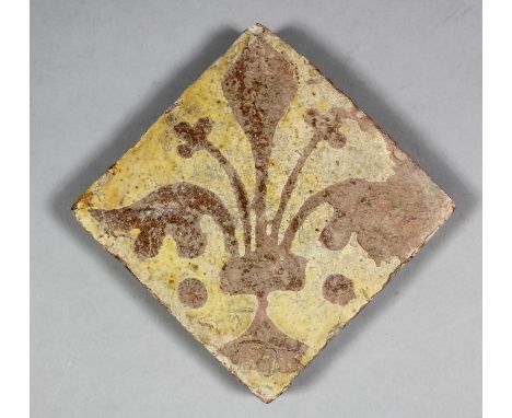 An English Medieval encaustic tile decorated in reversing technique with a fleur-de-lis design, 5ins diameter, set diagonally
